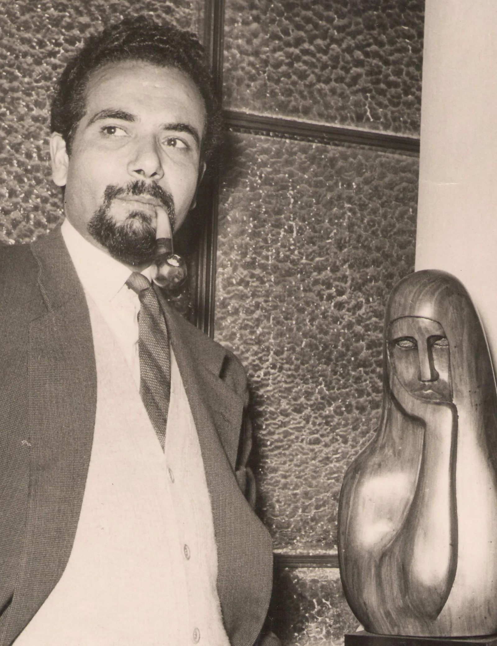 Gamal El-Sagini beside one of his wooden sculptures