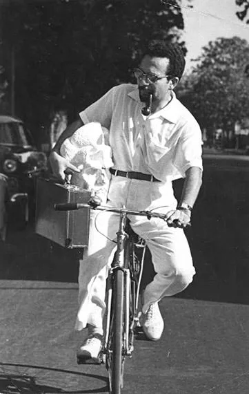 Gamal El-Sagini on his bicycle, carrying a plaster head